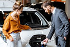 Mann und Frau stehen vor einem Auto