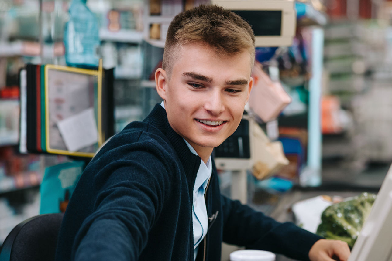 Junge Person an Supermarktkasse