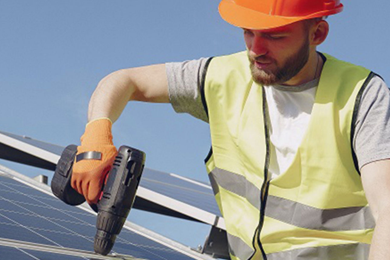 Mann auf dem Dach bringt Solarpanele an