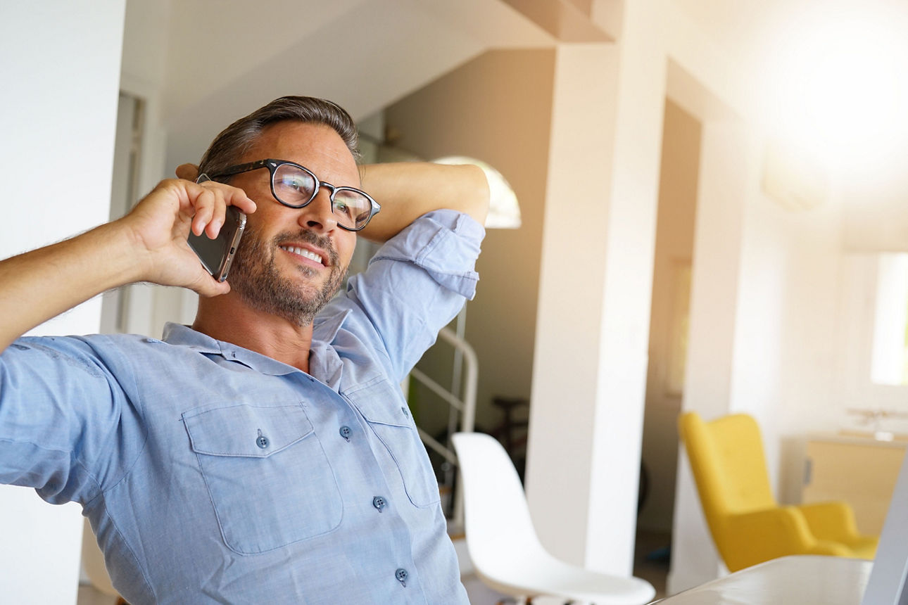 Mann mit Brille telefoniert mit dem Handy