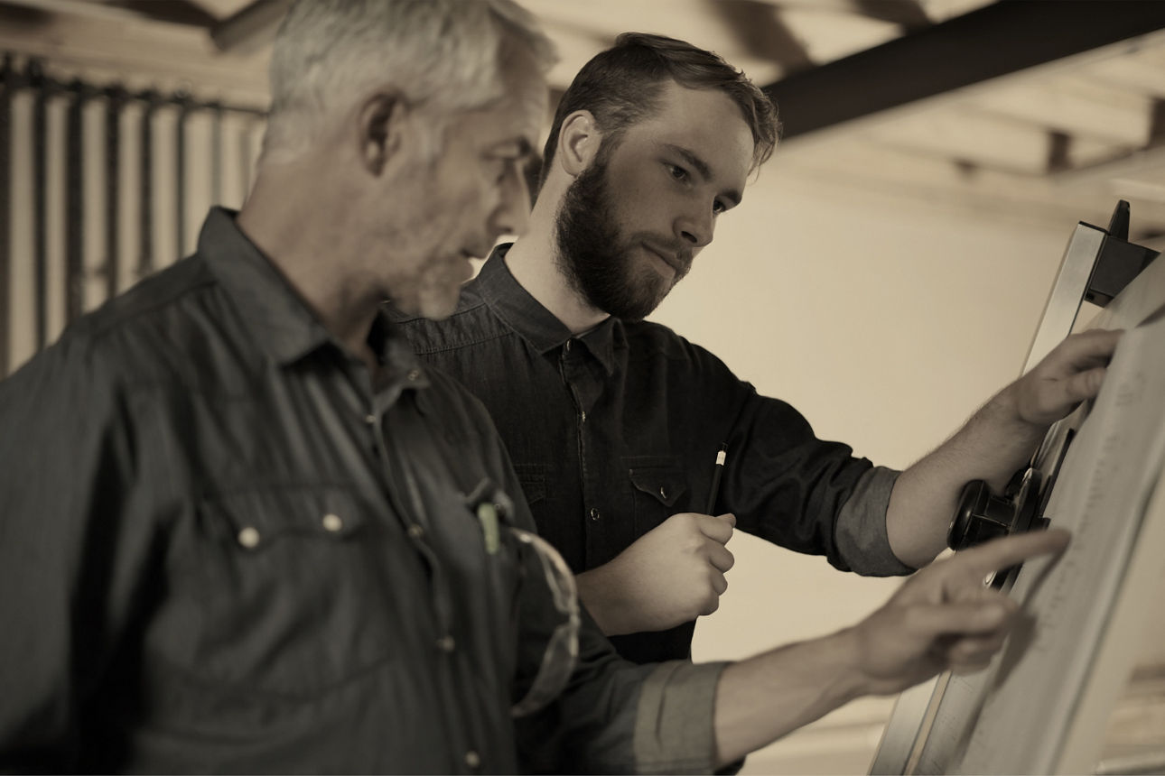 Zwei Männer schauen auf ein Flipchart