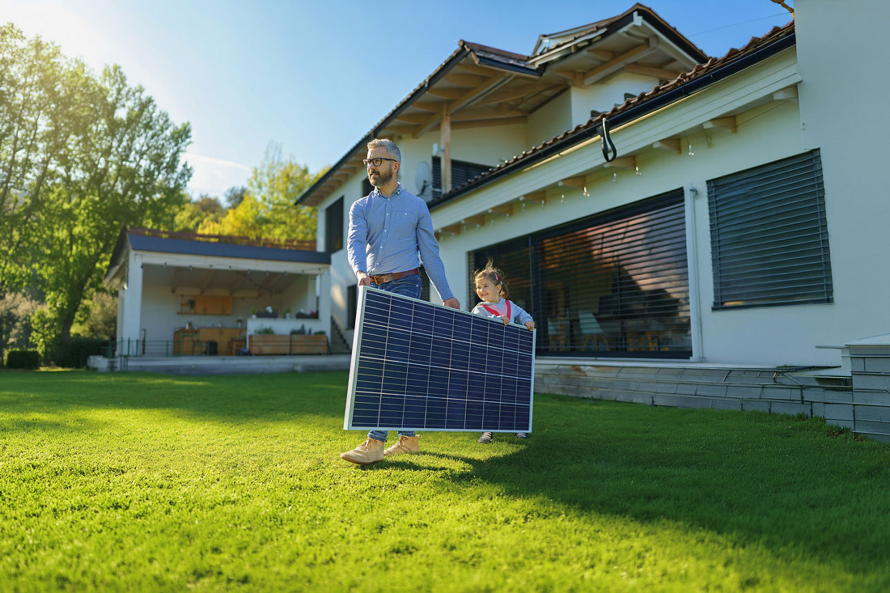 Mann mit Kind trägt ein Solar-Panel