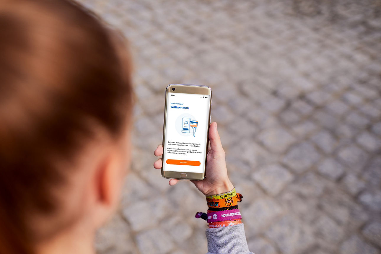 Junge Frau schaut auf ihr Smartphone mit geöffneter VR SecureGo plus App