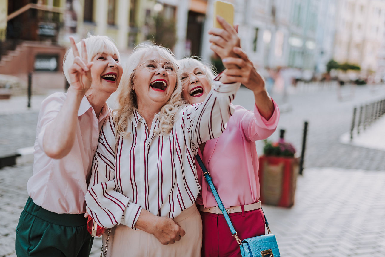 Drei ältere Damen machen ein Selfie und freuen sich