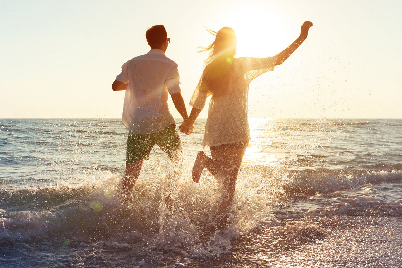 Mann und Frau laufen gemeinsam ins Meer