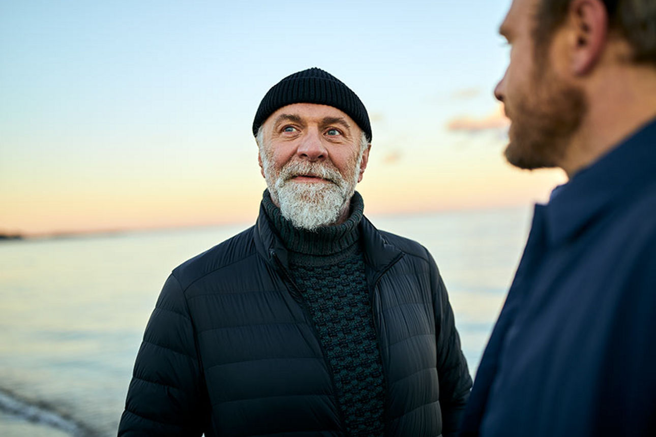 Zwei Männer im Gespräch am Meer