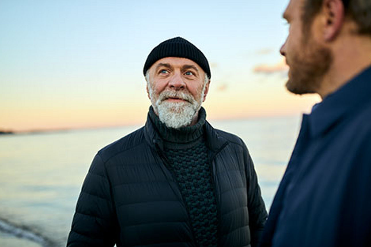 Zwei Männer im Gespräch am Meer