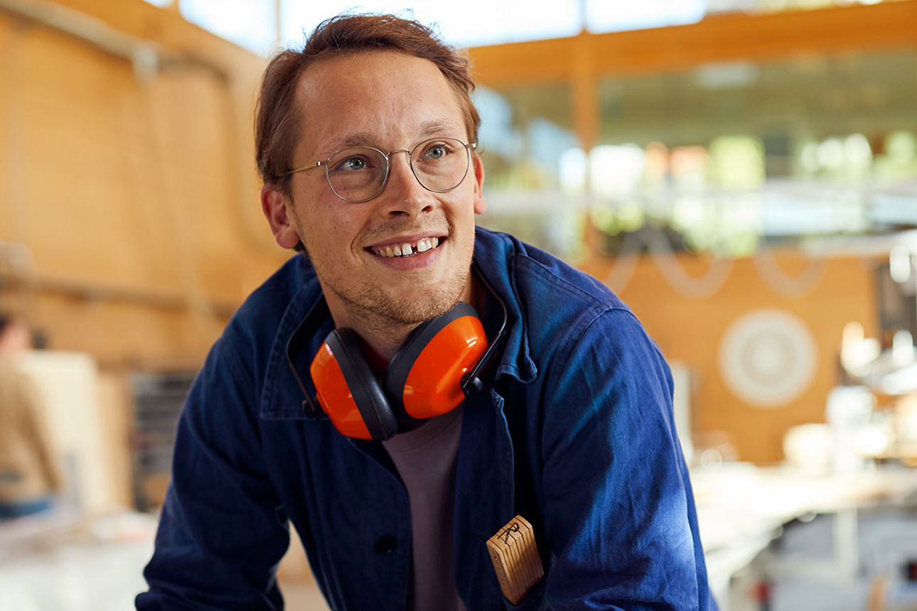 Junger Mitarbeiter in einer Fabrikhalle