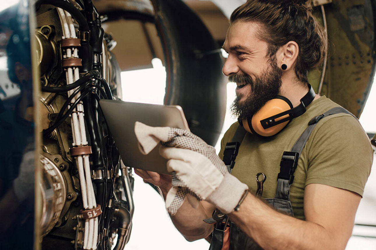 Ein Techniker steht lachend vor einer Maschine