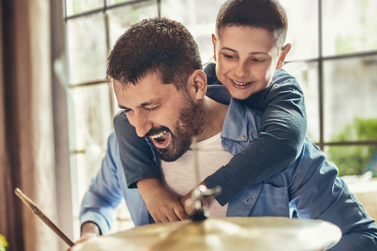 Vater und Sohn spielen zusammen Schlagzeug