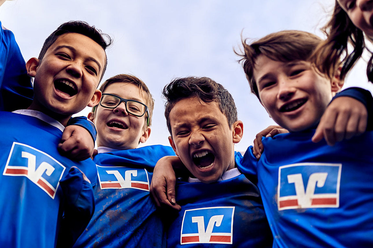 Lachende Kinder in Fußballtrikots