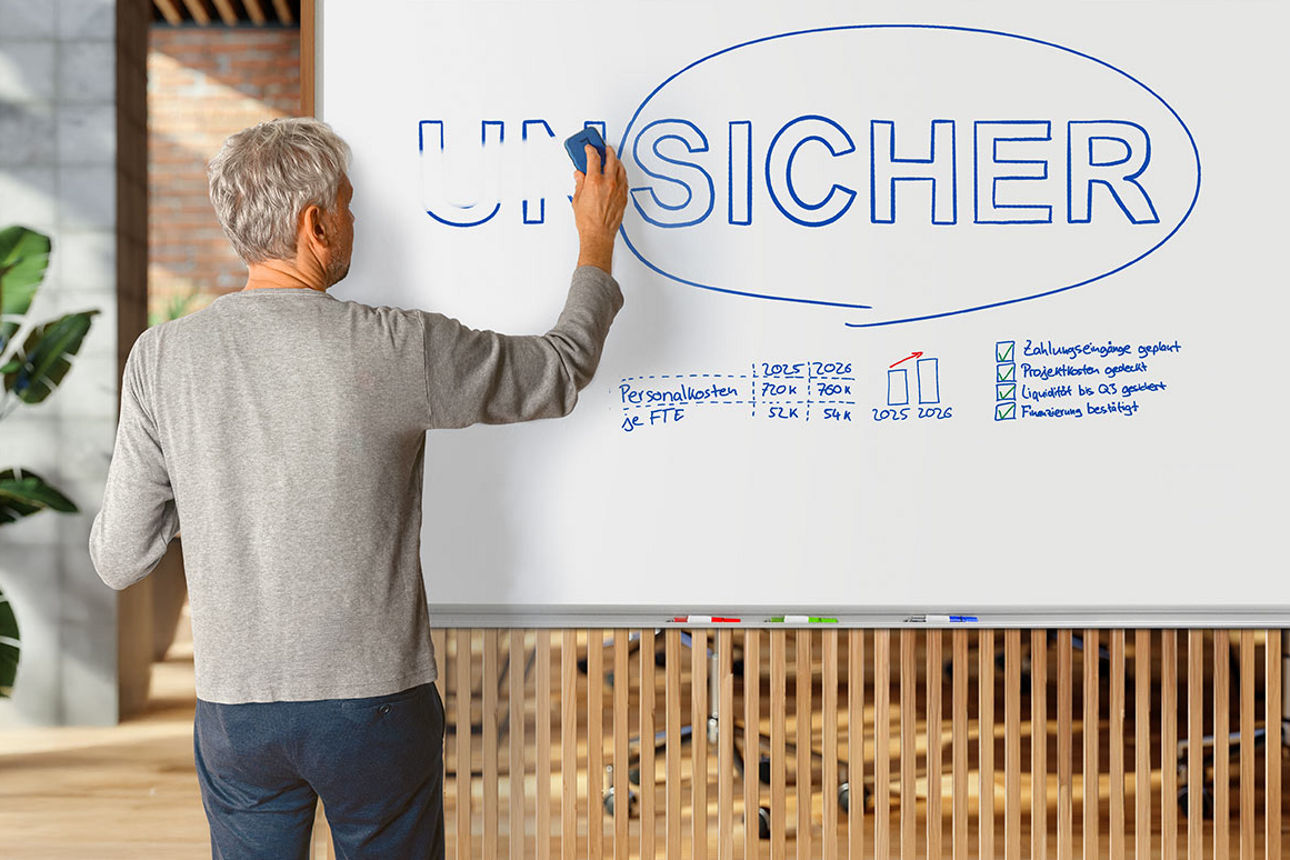 Mann steht vor einem Whiteboard mit der Aufschrift „Unsicher” und wischt die Vorsilbe „Un” weg